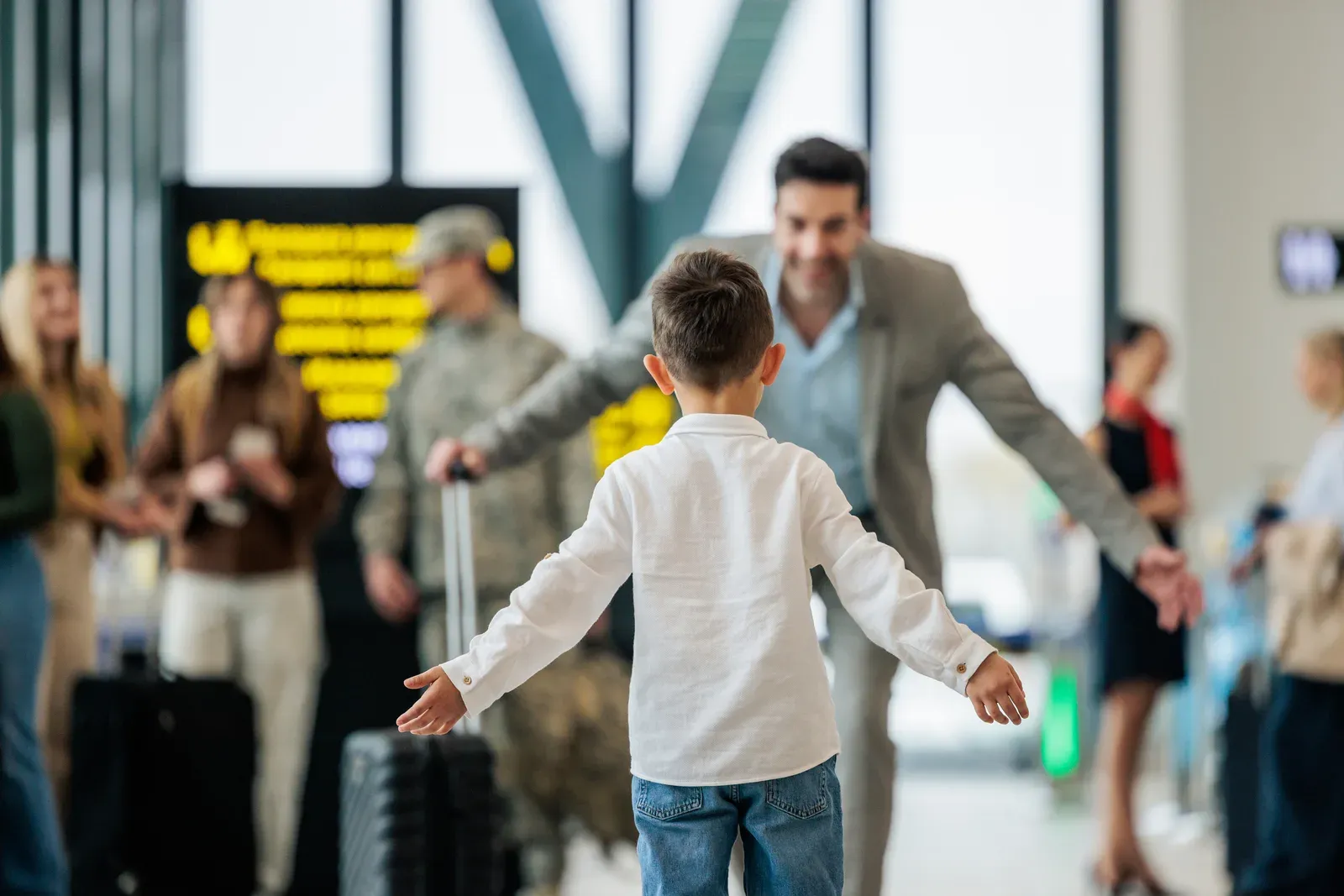 Father and son reuniting in an airport arrivals hall