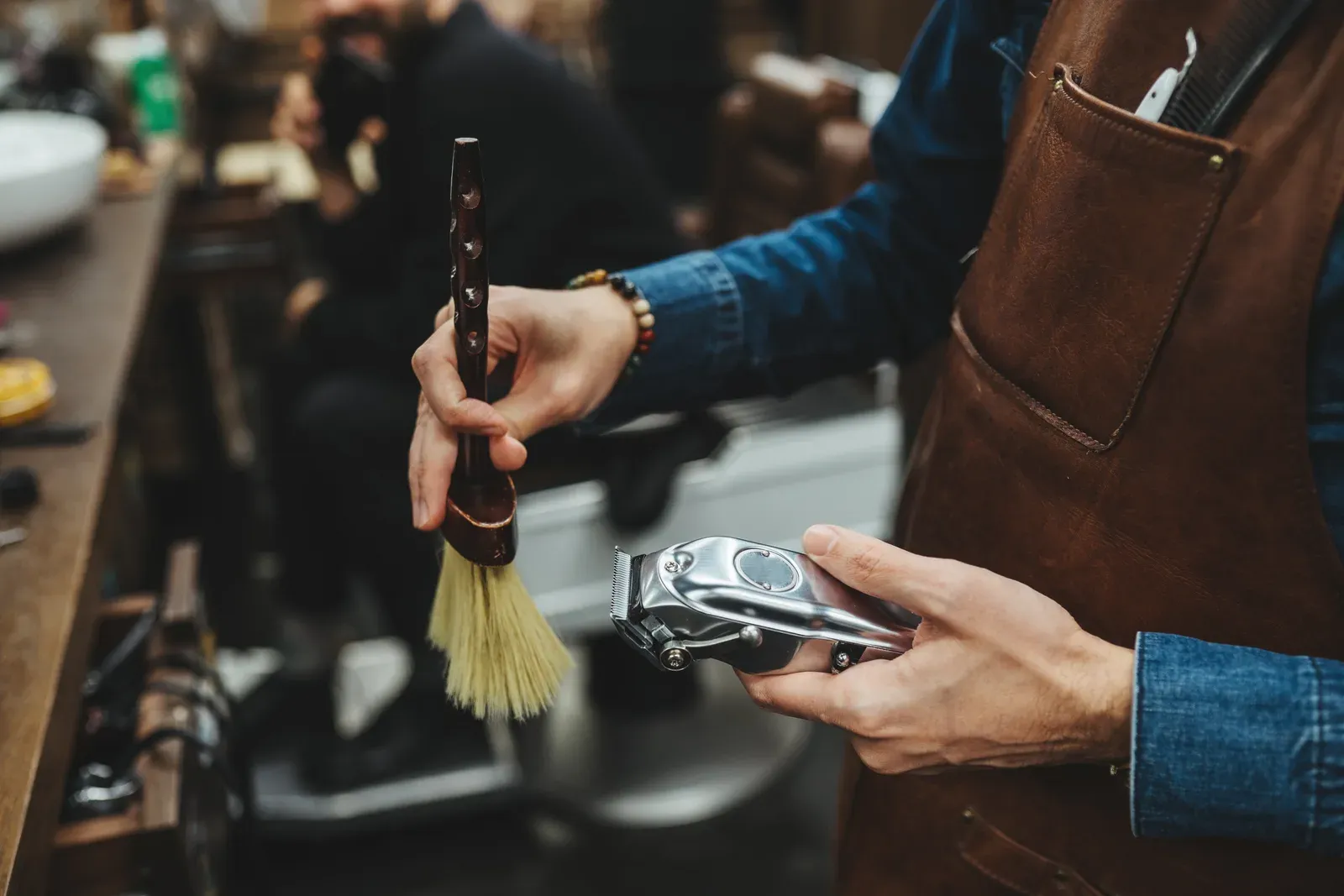 Barber preparing clippers and a brush before a haircut
