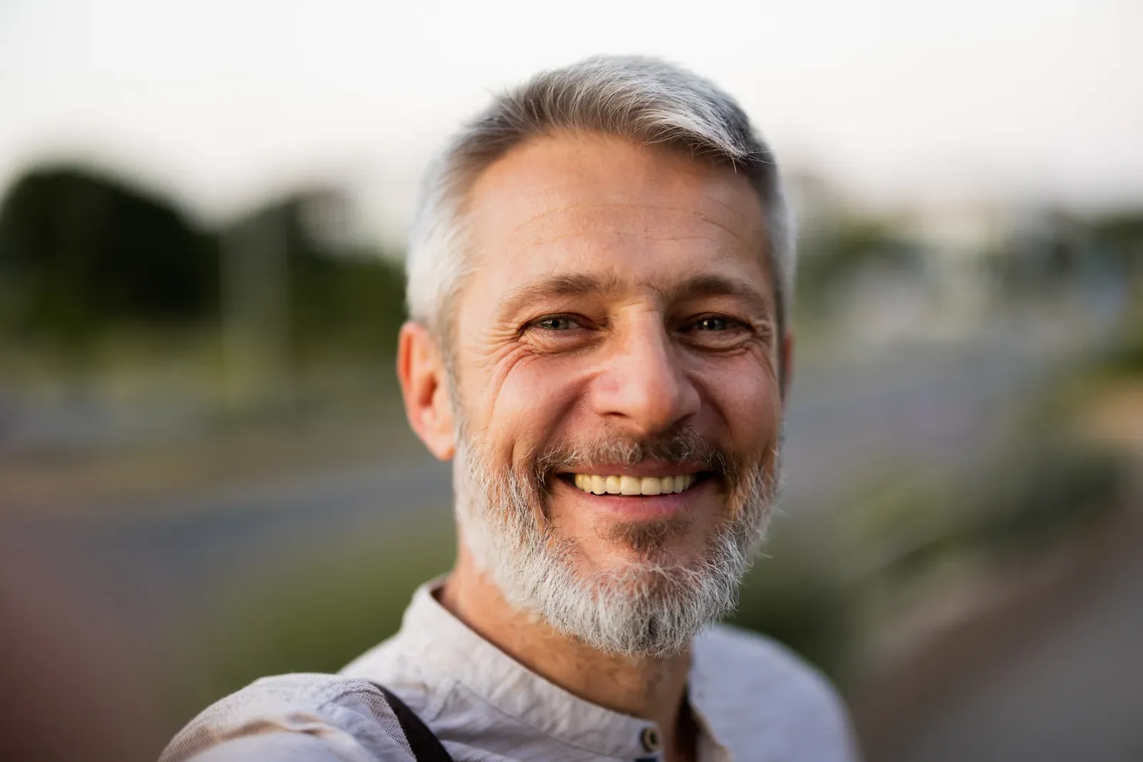 Smiling man with short grey hair and a grey beard