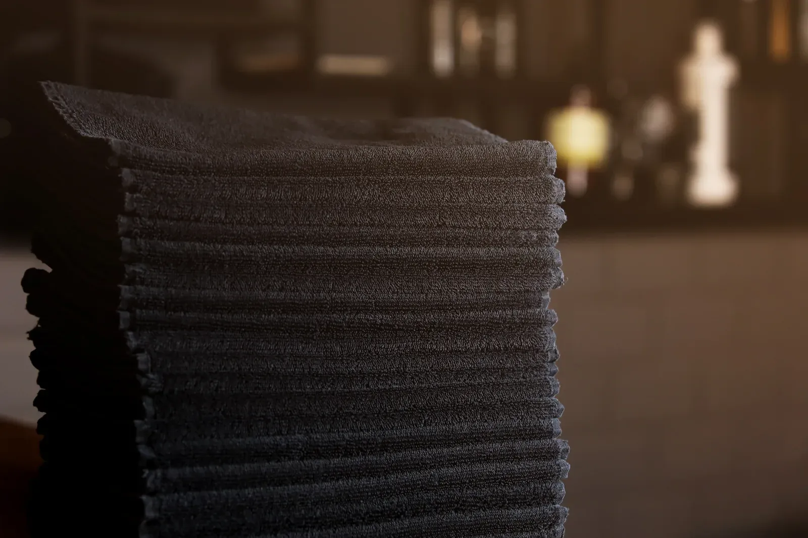 Stack of fresh black towels ready for hot towel treatments